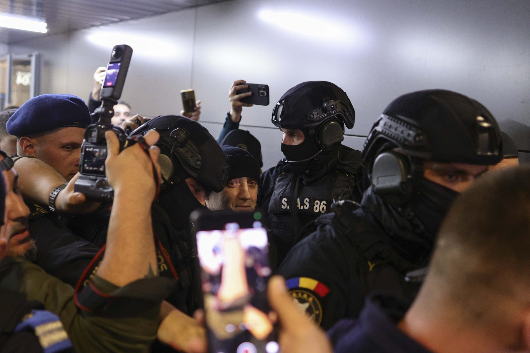 Primele imagini cu Horațiu Potra și membrii familiei sale după ce au fost aduși în țară. Șeful mercenarilor, înconjurat de mascați și presă pe Aeroportul Otopeni.